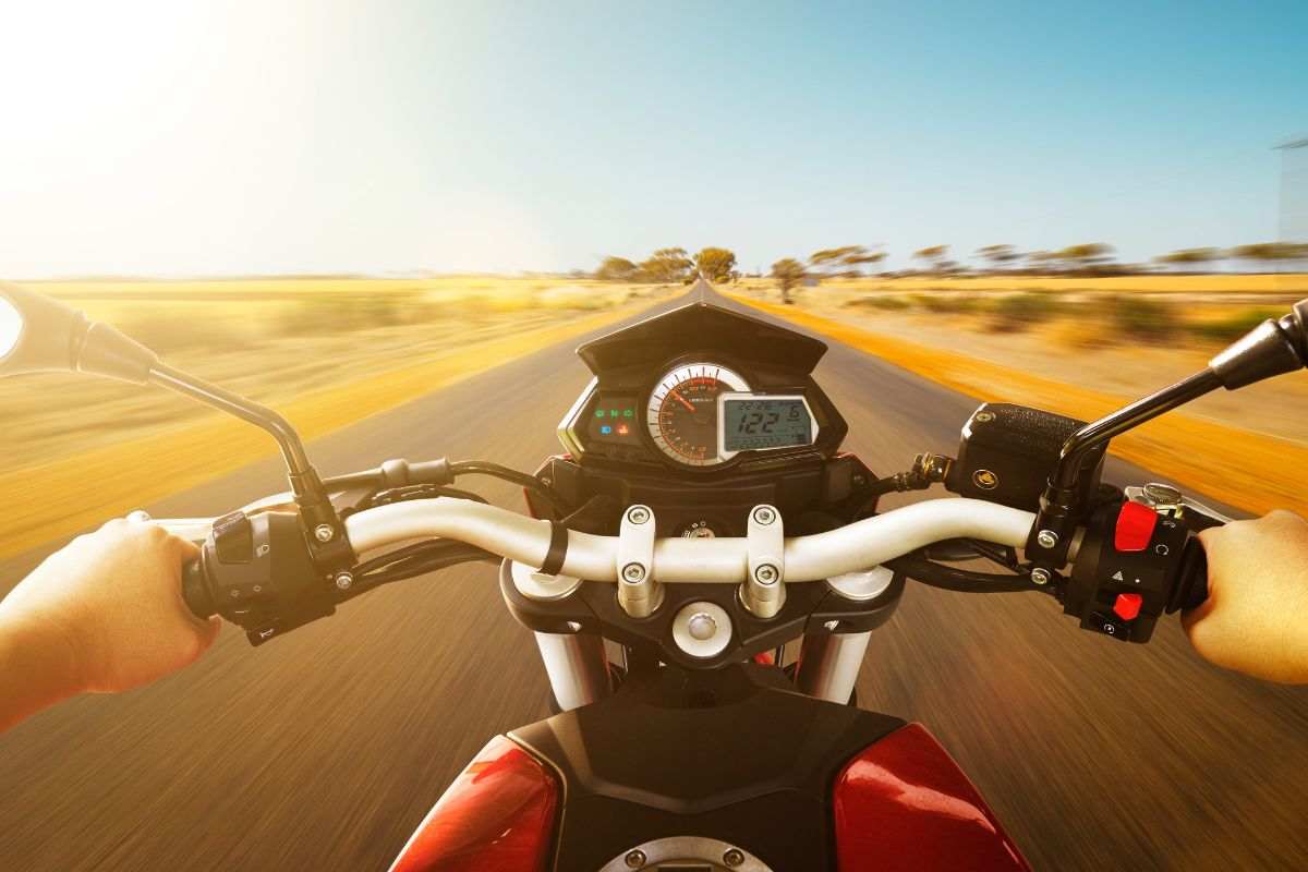 Guida in sella alla moto su una strada deserta