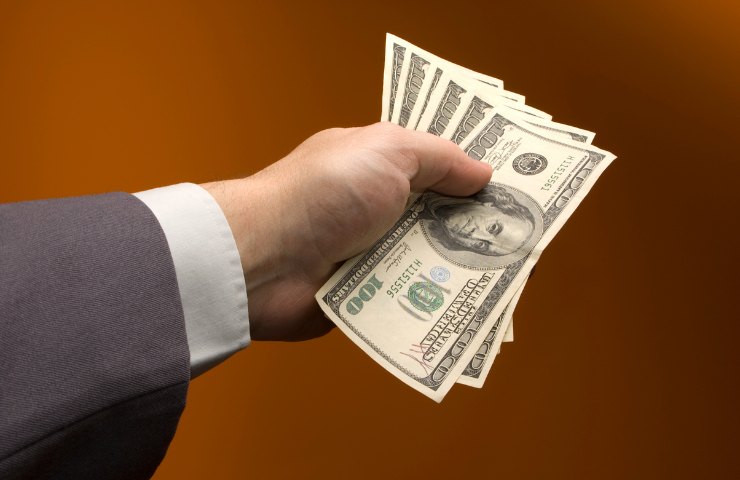 Una persona che tiene dei dollari statunitensi
