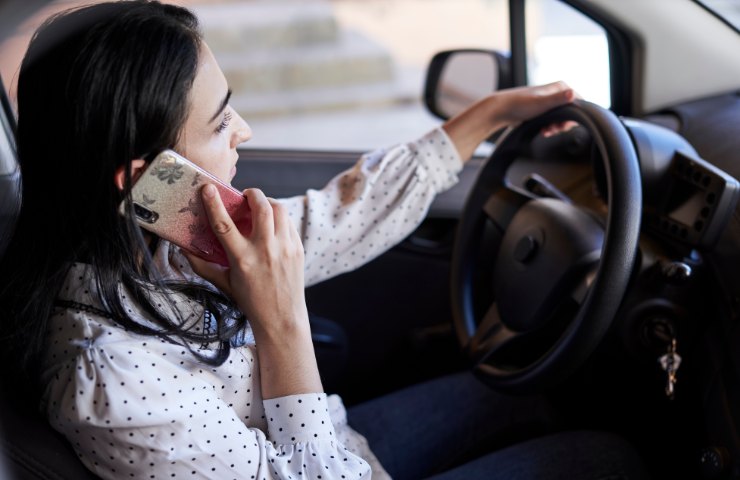 Una donna che usa lo smartphone alla guida