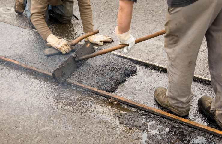 Degli operai che sistemano l'asfalto