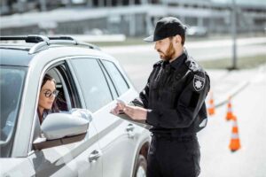 Un agente che svolge un controllo nei confronti di una automobilista