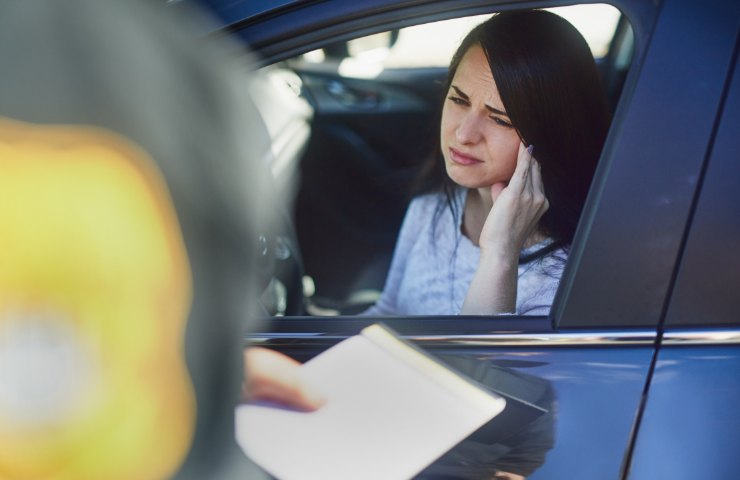 Una donna che riceve una multa in auto