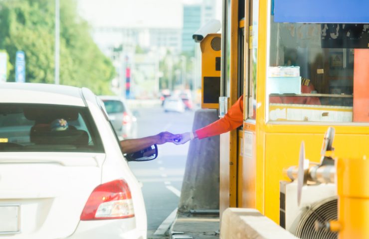 Un automobilista che paga il pedaggio autostradale