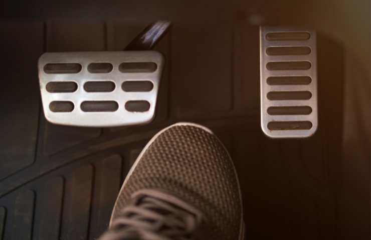Dei pedali di un'auto ed una scarpa