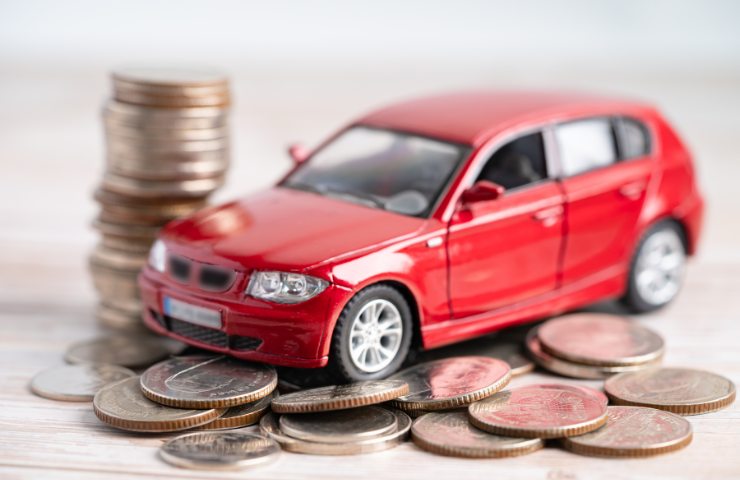 Un modellino di auto su dei soldi