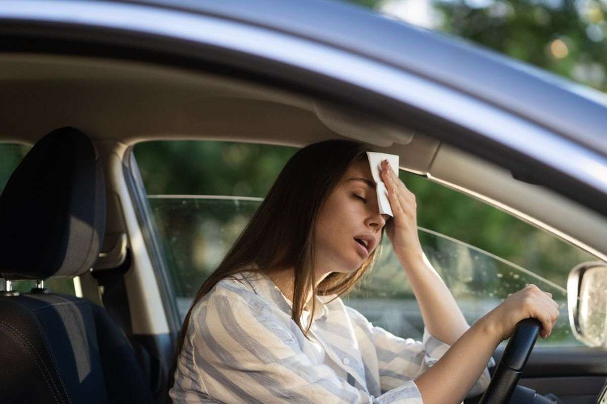 Ragazza alle prese con il caldo in auto