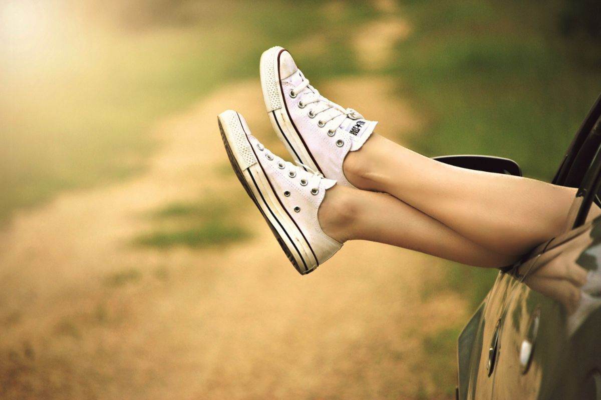 Ragazza con le gambe fuori dal finestrino