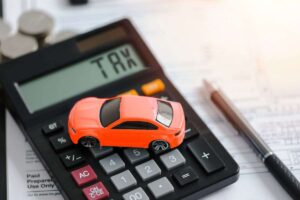 modellino di auto e calcolatrice con scritta tax